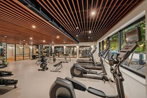 Arlington apartment for rent - Bright gym interior showing treadmills and exercise machines lined up under warm overhead lighting.