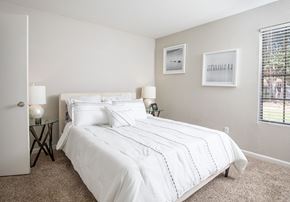 Houston apartment for rent - A bedroom with a large bed and two lamps.