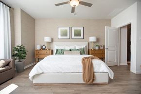 Pearland apartment for rent - A bedroom with a large bed and a ceiling fan.