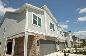 Pearland apartment for rent - A modern house with a grey exterior and a brick chimney.