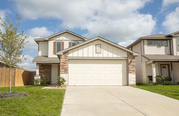 A white garage door is in the center of a driveway.