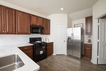 A kitchen with brown cabinets and a stainless steel refrigerator.