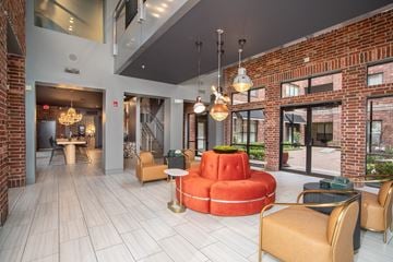 Houston apartment for rent - A modern living room with a red circular sofa and a wooden floor.
