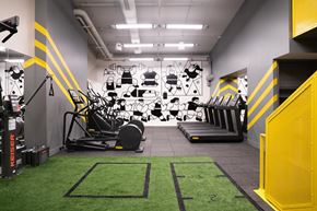 New York apartment for rent - A gym with a green carpet and a yellow stripe on the wall.