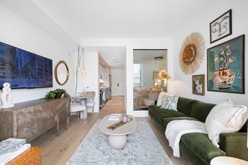 Washington apartment for rent - A living room with a green couch and a large painting on the wall.