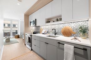 Washington apartment for rent - A kitchen with a white counter top and grey cabinets.