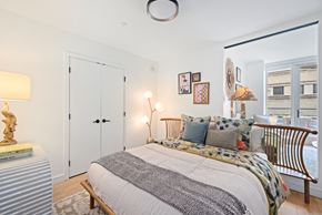 Washington apartment for rent - A bedroom with a bed, nightstand, and a window overlooking a cityscape.
