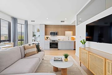Washington apartment for rent - A modern living room with a grey sofa and a white coffee table.
