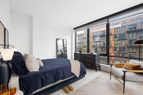 Washington apartment for rent - A bedroom with a large bed and a view of a building with the sign "Waterfront" on it.