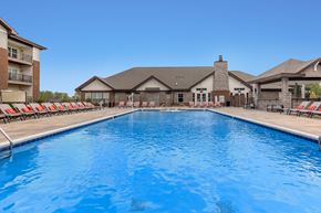 Louisville apartment for rent - A large swimming pool in front of a building with a clear blue sky.