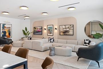 Doral apartment for rent - A modern living room with a white sofa set and a large mirror.