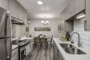 Wilsonville apartment for rent - Galley kitchen with stainless steel appliances and dining space at Canyon Creek Apartments, Oregon