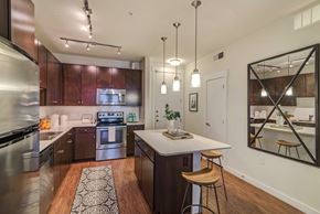 Austin apartment for rent - A modern kitchen with dark wood cabinets and stainless steel appliances.