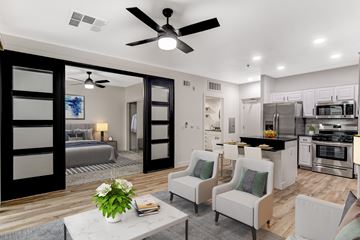 Las Vegas apartment for rent - A modern kitchen with a breakfast bar and a living room area with a sofa and chairs.