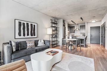 Chicago apartment for rent - A modern living room with a grey couch and a white coffee table.
