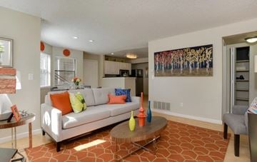Westminster apartment for rent - A living room with a white couch and orange pillows.