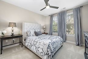 Raleigh apartment for rent - A bedroom with a large bed and a ceiling fan.
