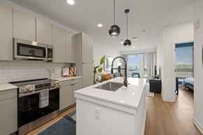 Charlotte apartment for rent - A modern kitchen with a stove top oven and microwave above it.