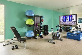 Denver apartment for rent - A home gym with a variety of exercise equipment including a stationary bike, a rowing machine, and a bench press.