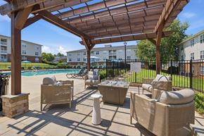 Hillsborough apartment for rent - A patio with a pool and chairs under a wooden pergola.
