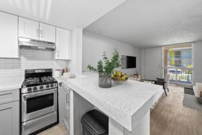 Phoenix apartment for rent - A kitchen with a stove, oven, and a table with a bowl of fruit on it.