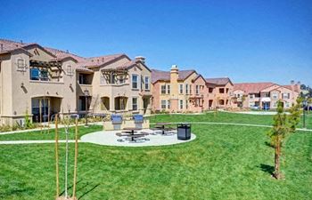 A sunny day at a residential area with houses and a green lawn.