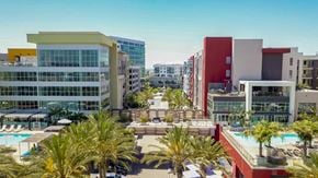 San Diego apartment for rent - A modern building complex with a pool in the foreground.