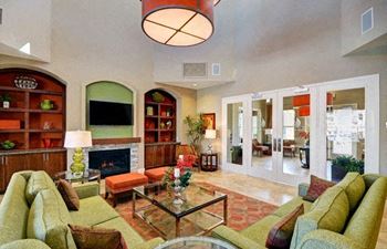 A living room with a fireplace and a glass coffee table.