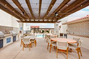 Albuquerque apartment for rent - a patio with tables and chairs and a pool in the background