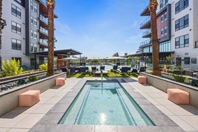 Scottsdale apartment for rent - a swimming pool in the middle of an apartment building with palm trees