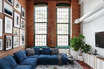 Philadelphia apartment for rent - A living room with a blue couch and a brick wall.
