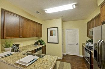 A kitchen with granite countertops and stainless steel appliances