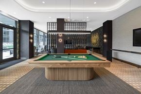 Washington apartment for rent - A pool table in a room with a black and gold decor.