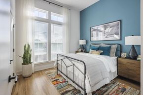 Charlotte apartment for rent - A bedroom with a bed, nightstands, and a plant.