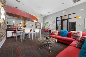 Avondale apartment for rent - A living room with a red couch and a glass coffee table.