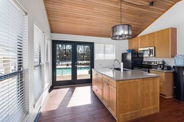 Chapel Hill apartment for rent - A kitchen with wooden cabinets and a black trash can.
