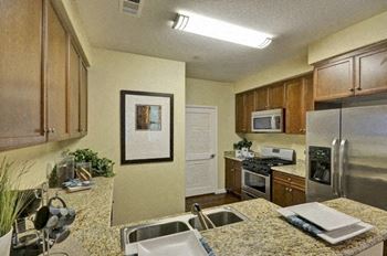 A kitchen with granite countertops and stainless steel appliances.