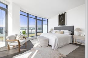 Washington apartment for rent - A bedroom with a large bed and a chair by the window.