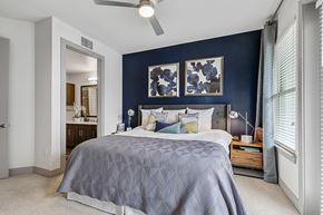 Dallas apartment for rent - A bedroom with a bed, nightstand, and a ceiling fan.