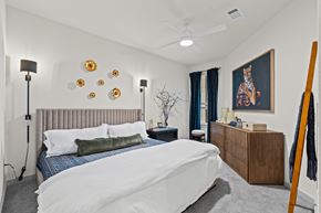 Prosper apartment for rent - A bedroom with a bed, nightstand, and a painting on the wall.