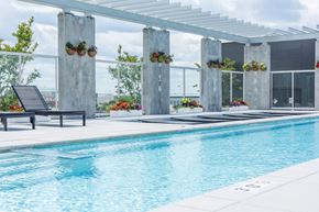 Washington apartment for rent - Luxury community swimming pool area surrounded by architectural concrete pillars and vibrant hanging flower baskets.