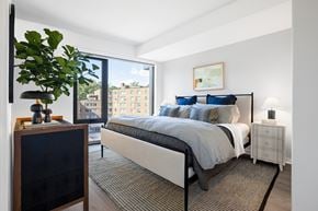 Washington apartment for rent - A bedroom with a large bed and a plant on a table.