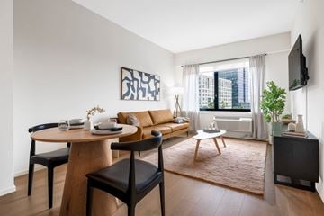 Jersey City apartment for rent - A modern living room with a wooden table and chairs.