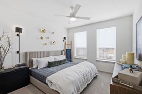 Prosper apartment for rent - A bedroom with a bed, nightstand, and a ceiling fan.