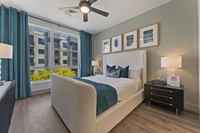Scottsdale apartment for rent - a bedroom with a large window and a bed and a ceiling fan