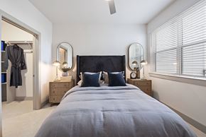 Houston apartment for rent - A bedroom with a large bed and two lamps on either side of it.