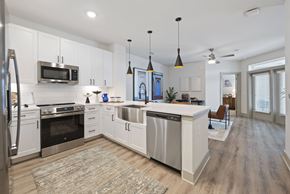 Houston apartment for rent - A modern kitchen with white cabinets and stainless steel appliances.
