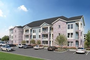 Mont Belvieu apartment for rent - A large pink building with a parking lot in front.