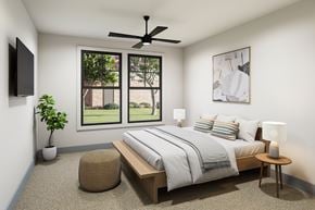Mont Belvieu apartment for rent - A bedroom with a large bed, a ceiling fan, and a window overlooking a garden.