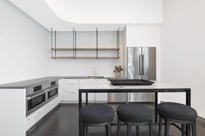 Vienna apartment for rent - A modern kitchen with white cabinets and a black countertop.